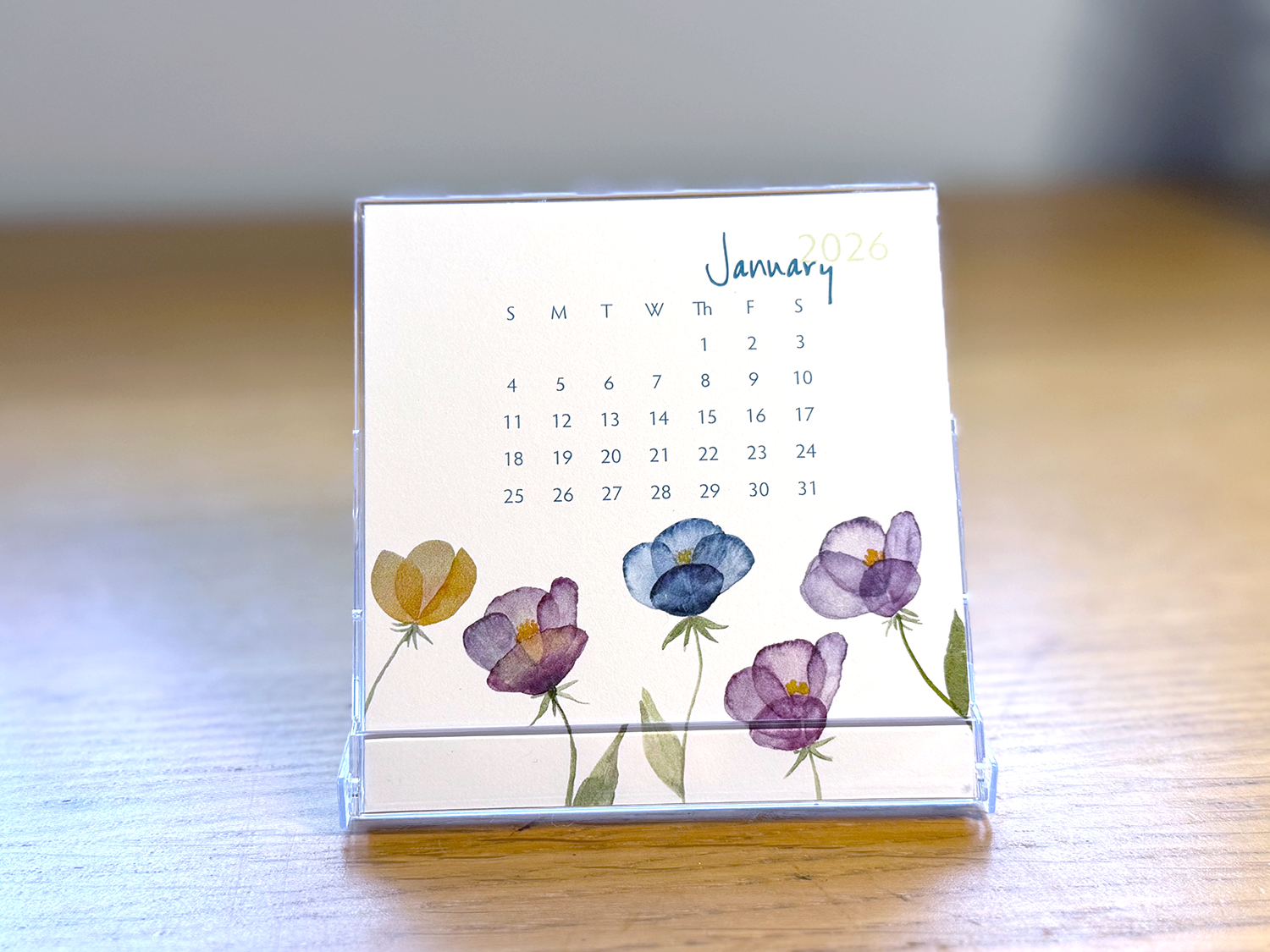 Calendar with floral design on a wooden surface