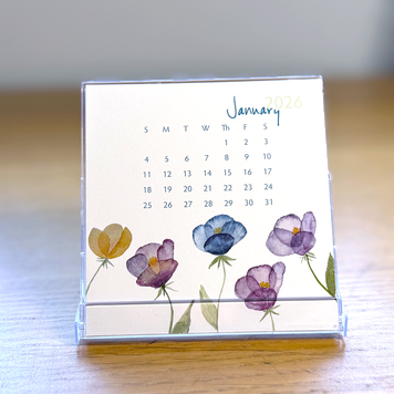 Calendar with floral design on a wooden surface