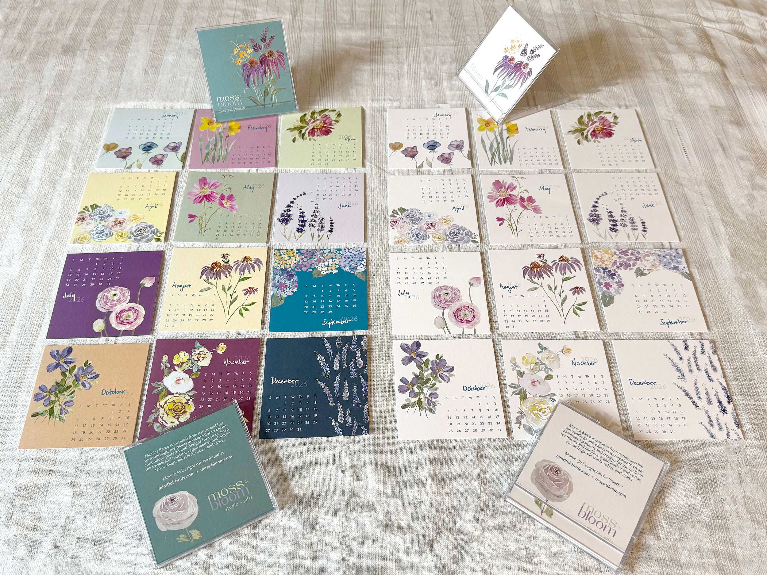 Collection of floral-themed calendars and cards on a textured surface