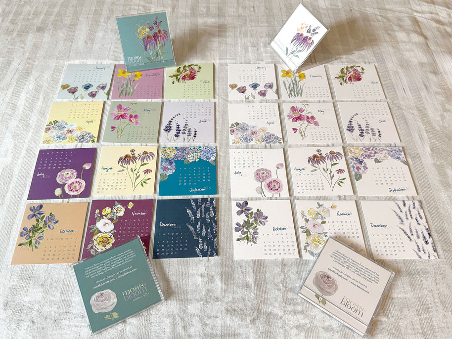 Collection of floral-themed calendars and cards on a textured surface