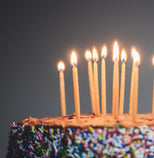 Birthday cake with lit candles against a dark background