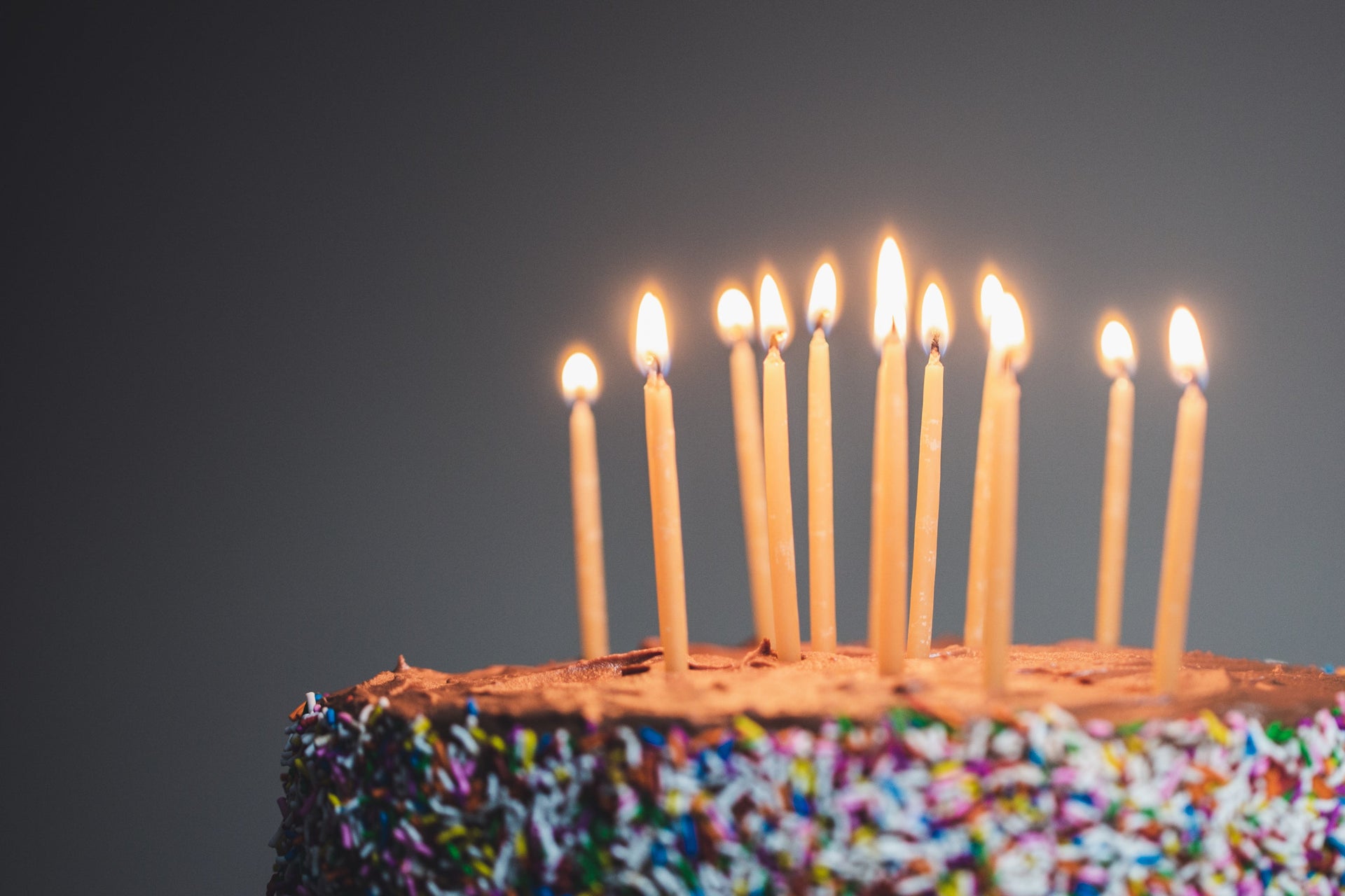 Birthday cake with lit candles against a dark background