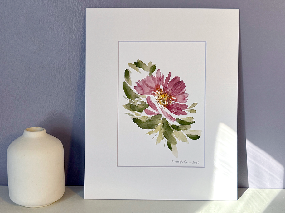 Framed floral artwork on a white surface with a purple wall background
