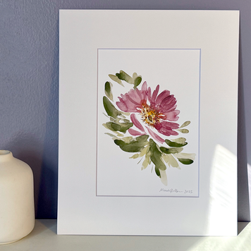 Framed floral artwork on a white surface with a purple wall background