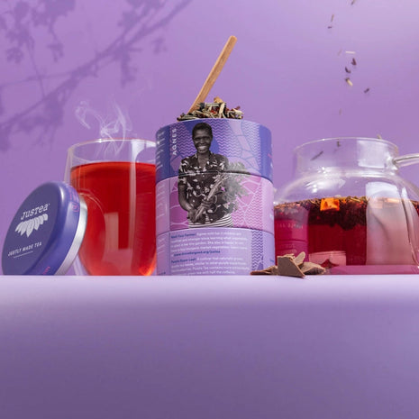 Tea packaging with a glass of red tea and a teapot on a purple background